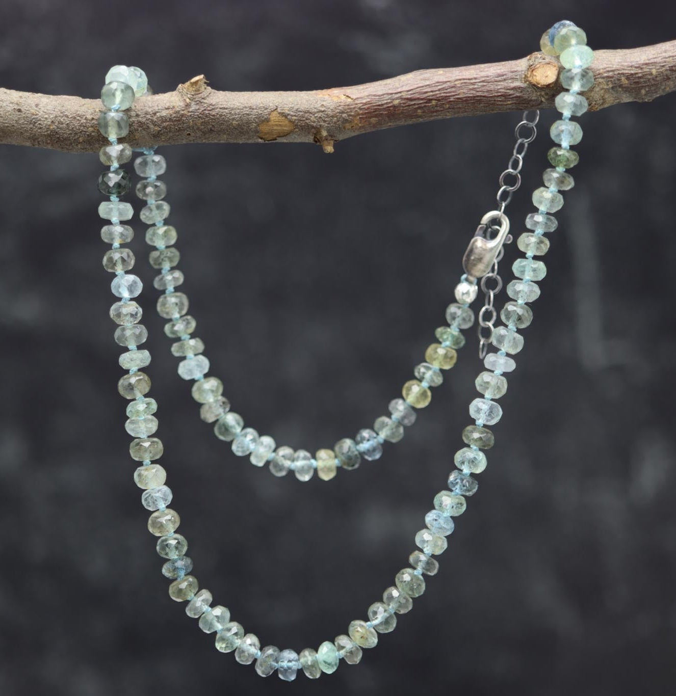 A 16 inch sterling silver necklace with moss aquamarine hand knotted beads, featuring a lobster claw closure.