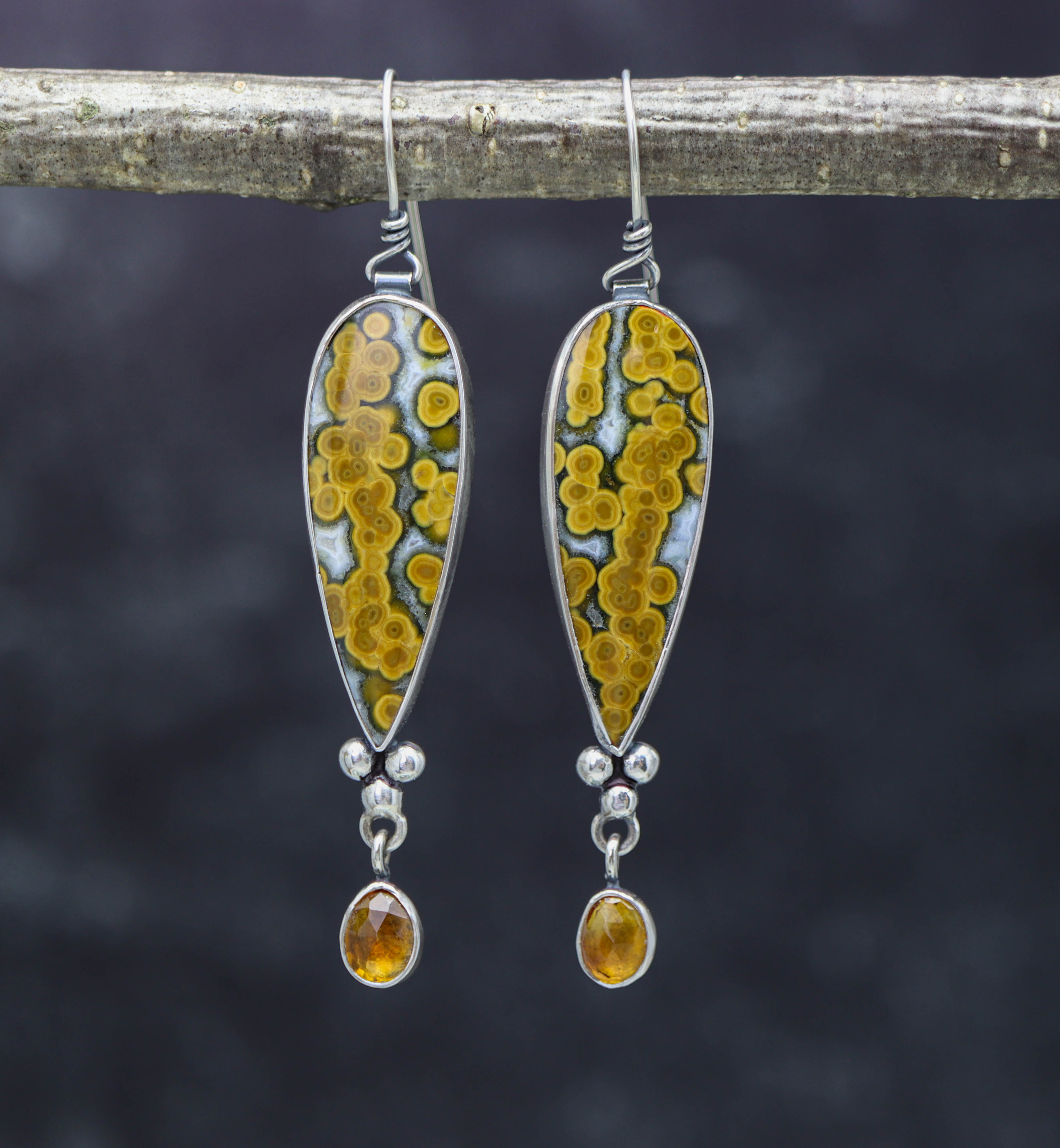 A pair of sterling silver dangle earrings featuring orbicular jaspers and faceted citrines, with a fish hook wire.