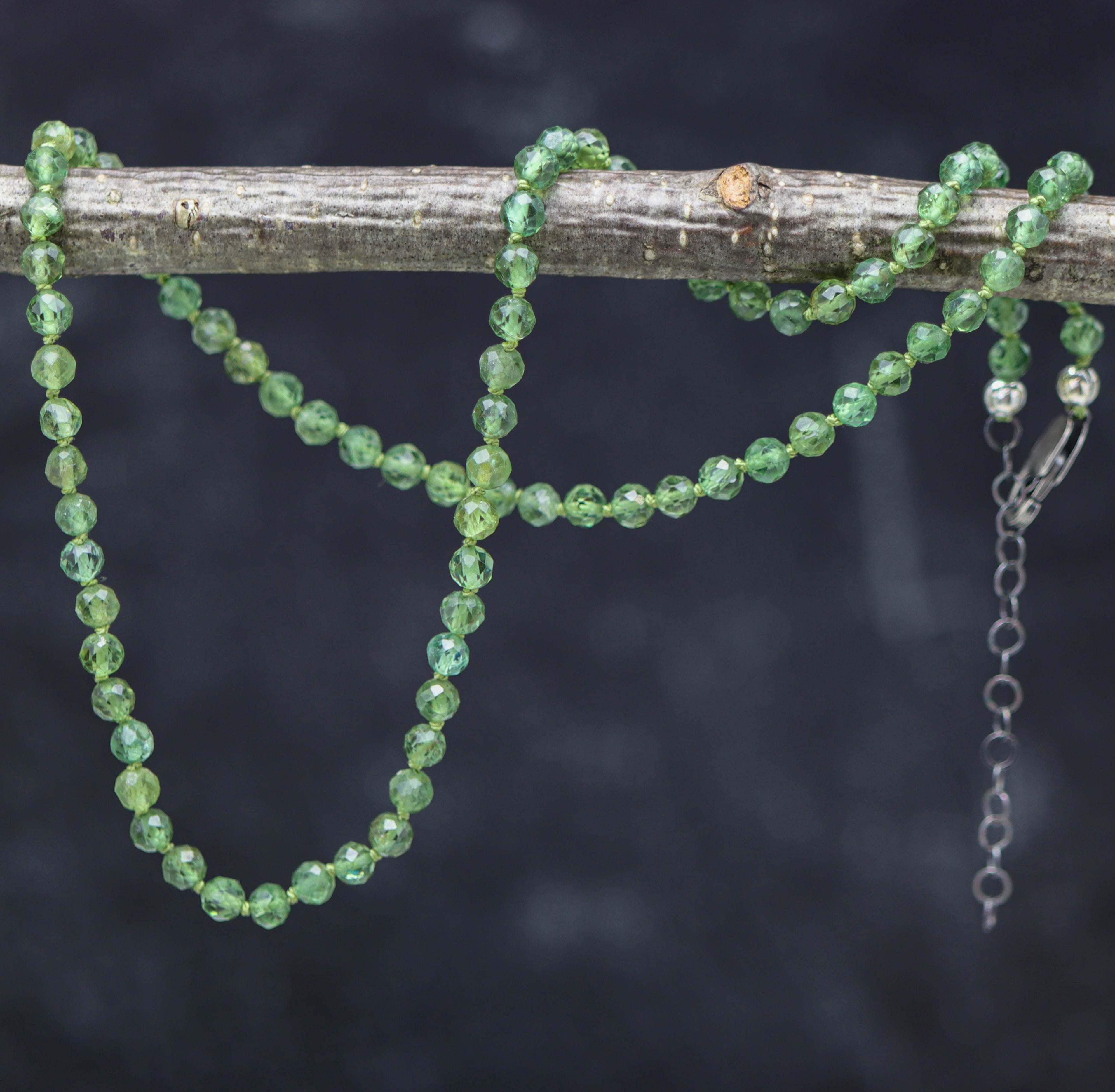 A hand knotted bead necklace with green apatite beads and a sterling silver lobster claw closure.