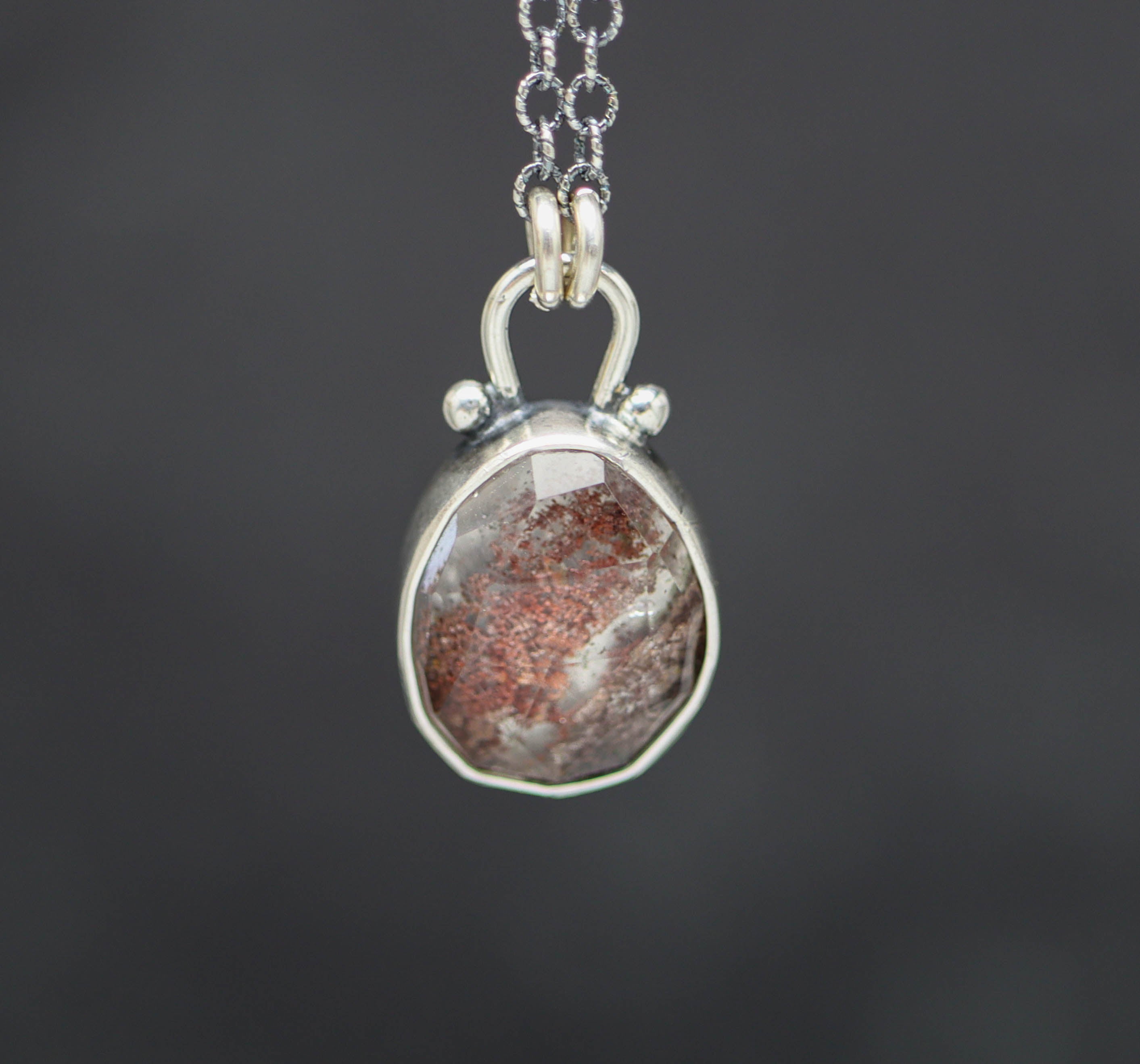 Silver pendant with a garden quartz on a dark background
