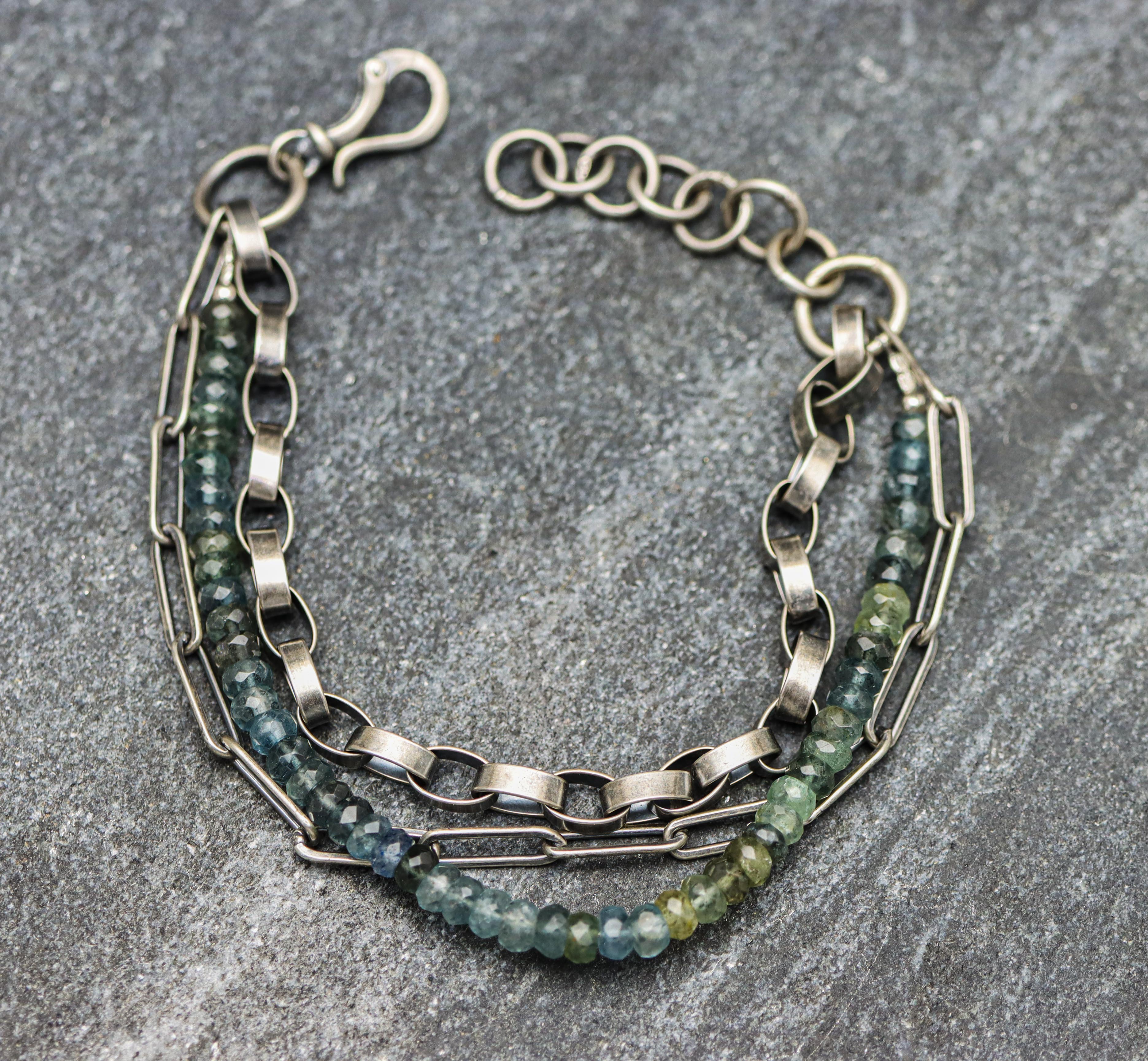 A multi-strand bracelet with a combination of sterling silver chains and gemstone beads, featuring moss aquamarine.