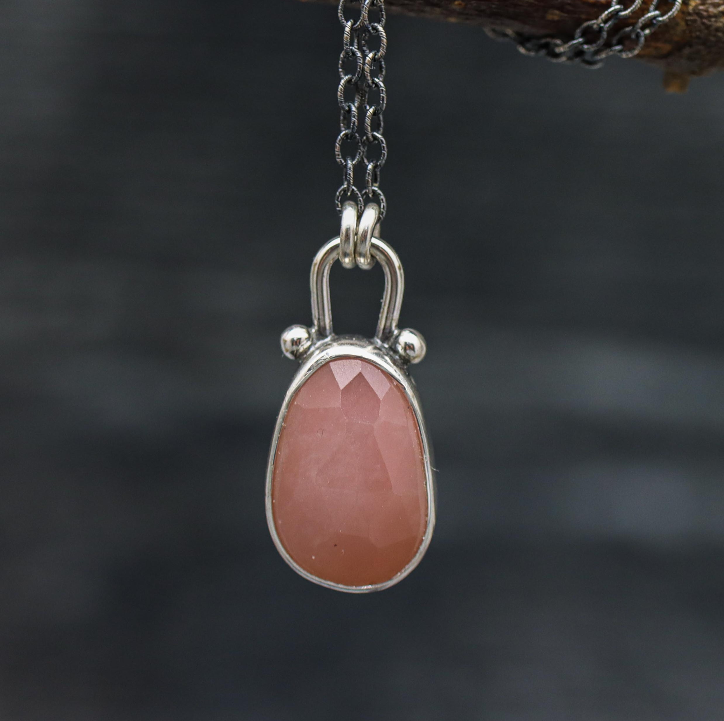 A sterling silver pendant necklace with a rose-cut guava quartz centerpiece, displayed on an oxidized cable link chain.