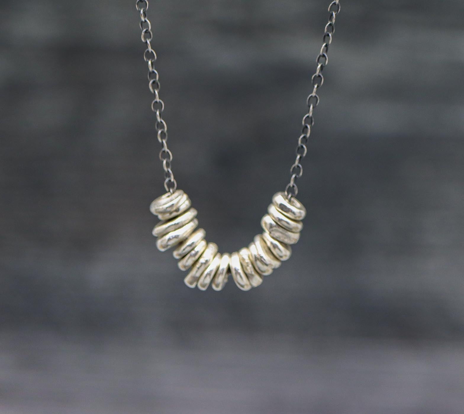 A necklace with oxidized cable link chain and silver nugget beads, with a lobster claw closure.