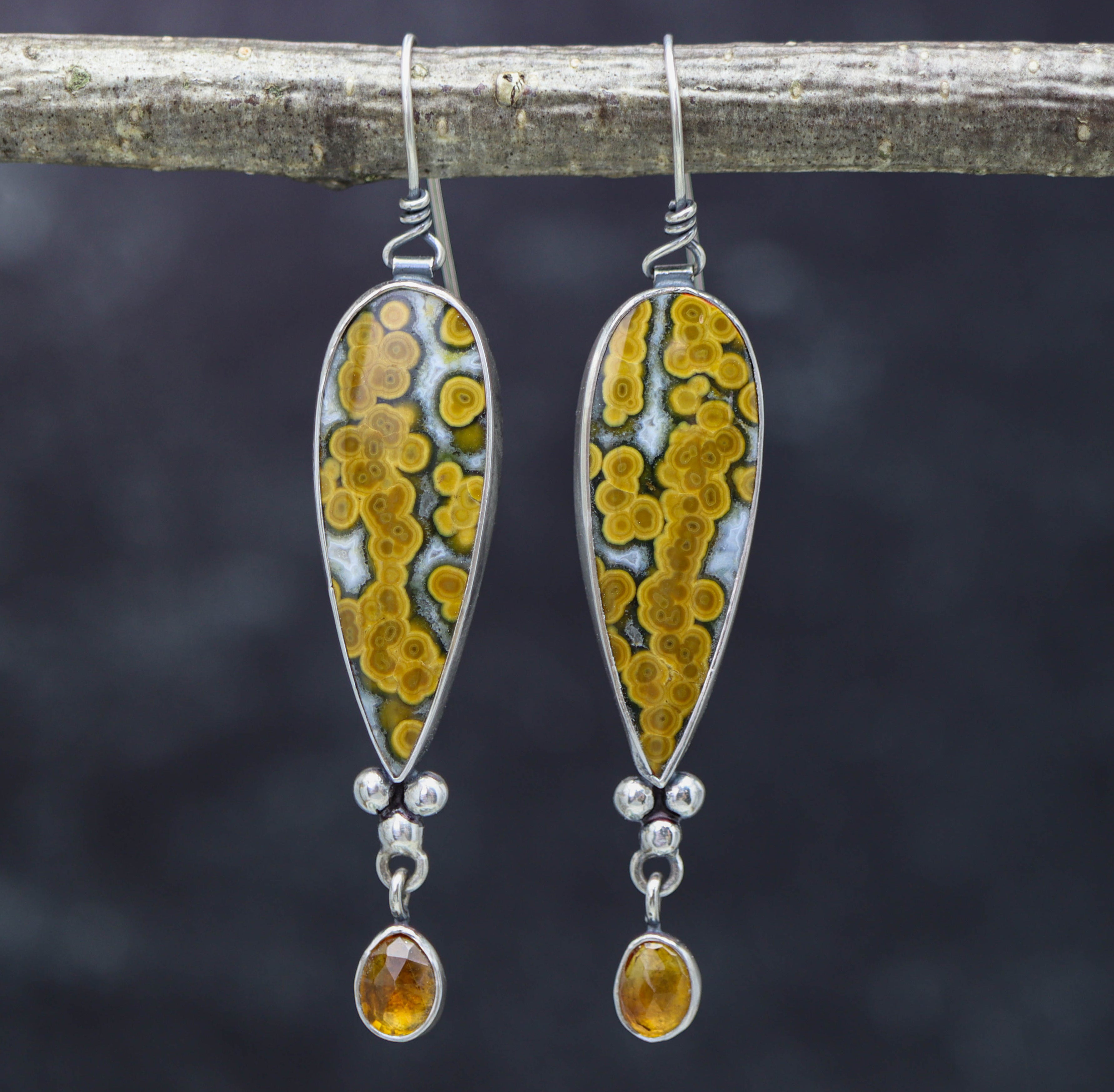 A pair of sterling silver dangle earrings featuring orbicular jaspers and faceted citrines, with a fish hook wire.