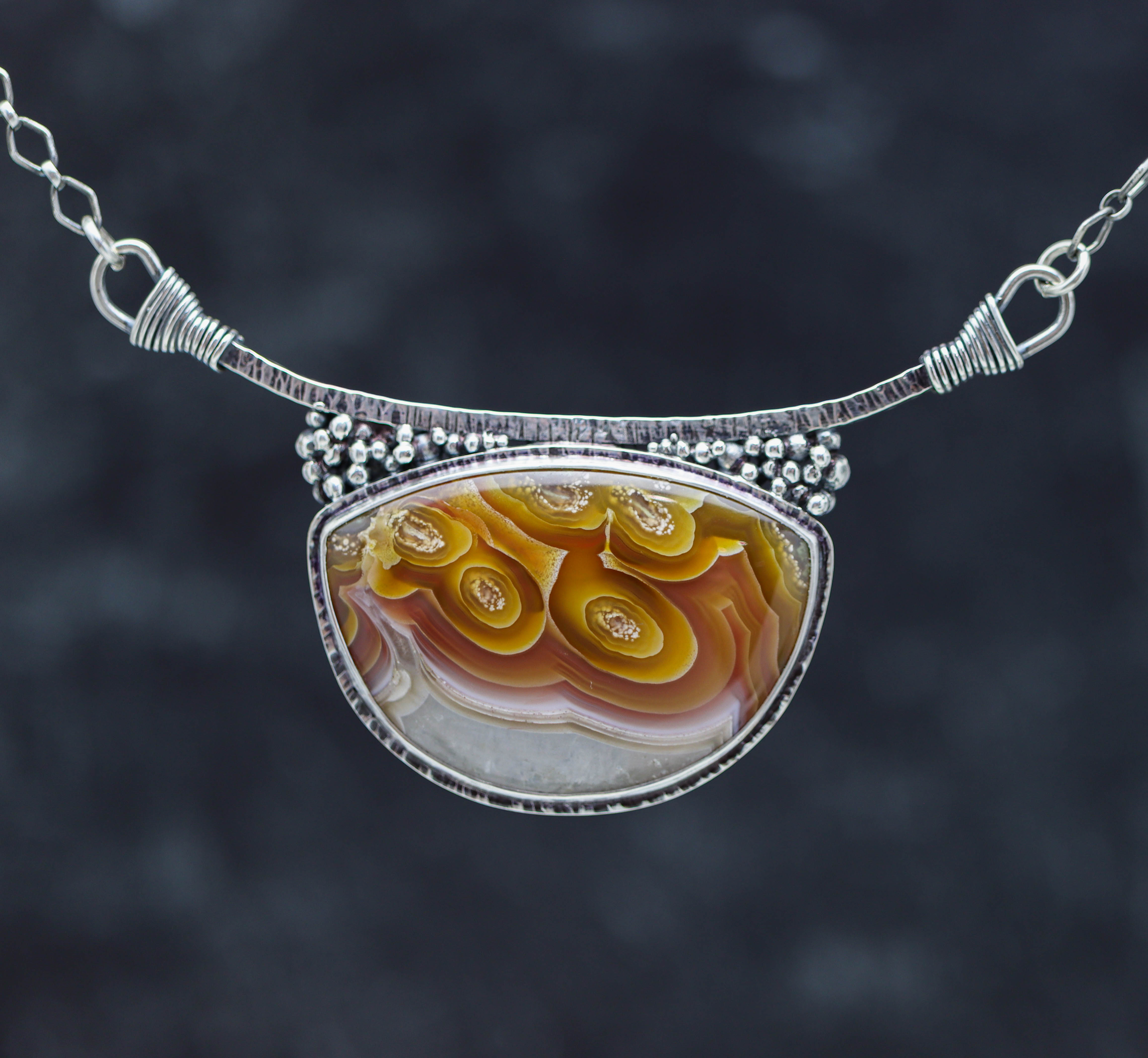 Necklace with a colorful pendant on a dark background