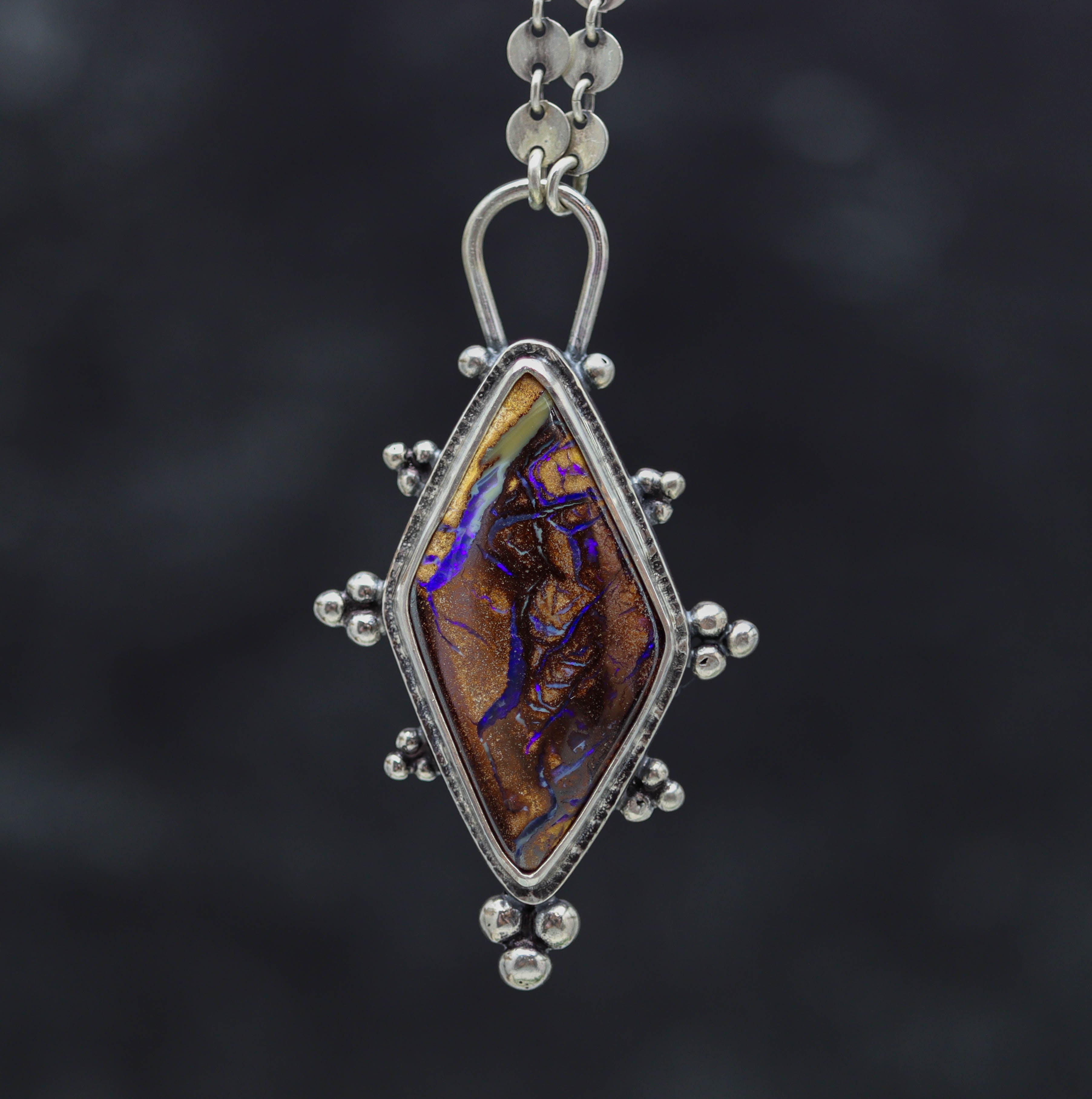 Silver pendant with a opal gemstone on a dark background