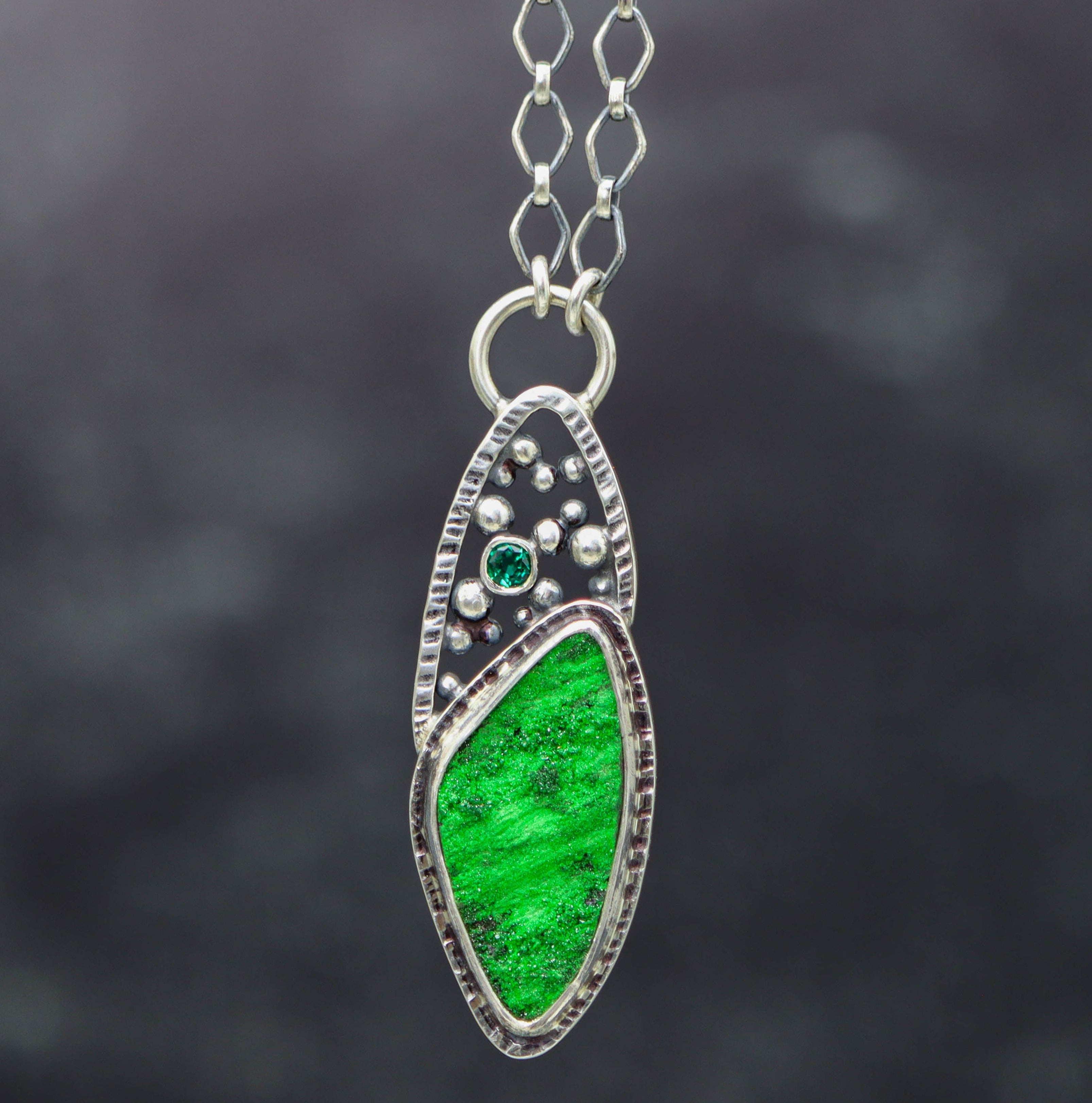 Necklace with a green pendant on a dark background